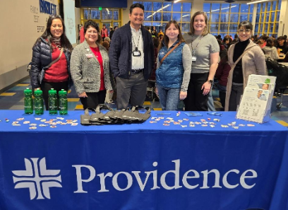 A group of people standing in front of a table with cards and cardsAI-generated content may be incorrect.